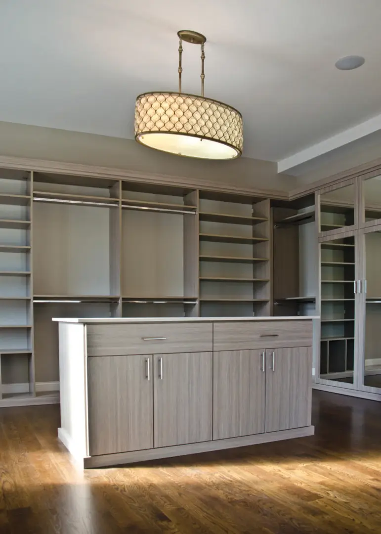 A large walk in closet with many shelves and drawers.