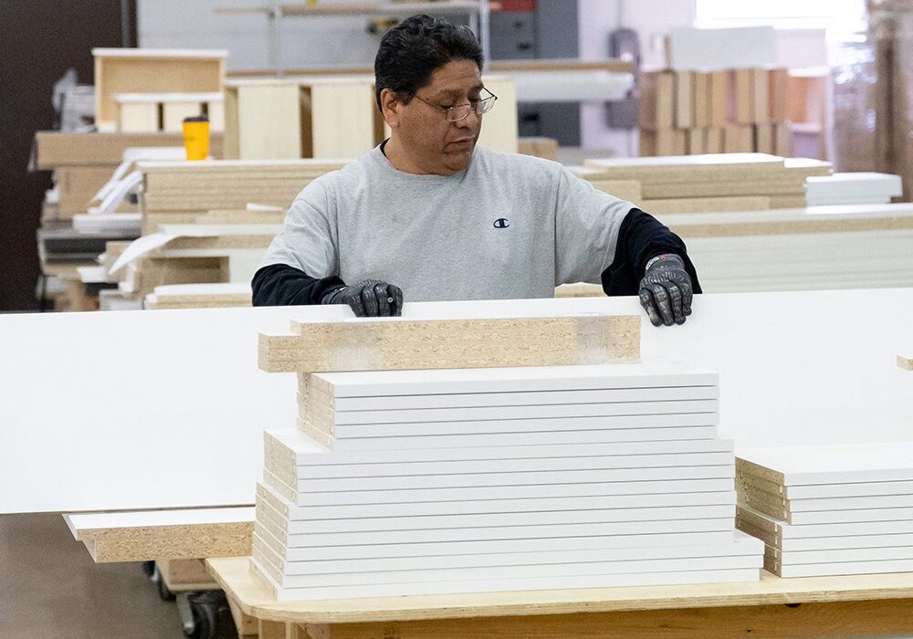 A man working in a factory with many boxes