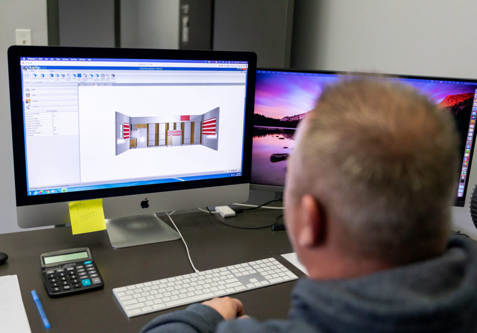 A man sitting at his computer desk looking at the screen.